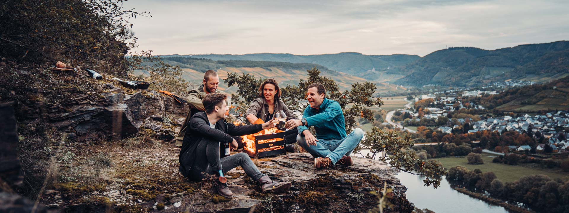 An inviting scene with two people sitting on a rock with a campfire, highlighted by the presence of the Crate Fireplace