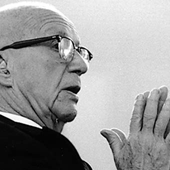 a man in a suit and tie is holding his hands up.