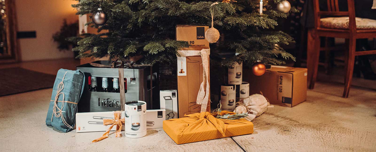 A christmas tree with presents on the floor