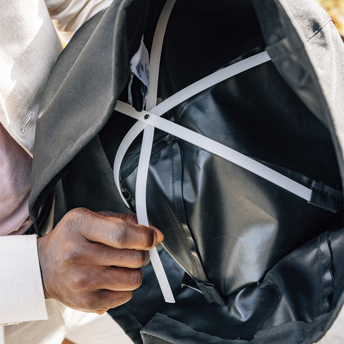 a man holding a black cover showing it from the inside with its structural elements. The 00815 Moon 45 Cover