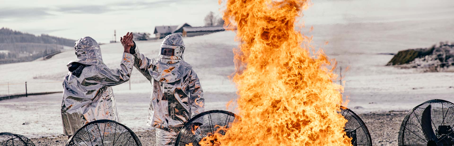 two people in armor standing around a fire.
