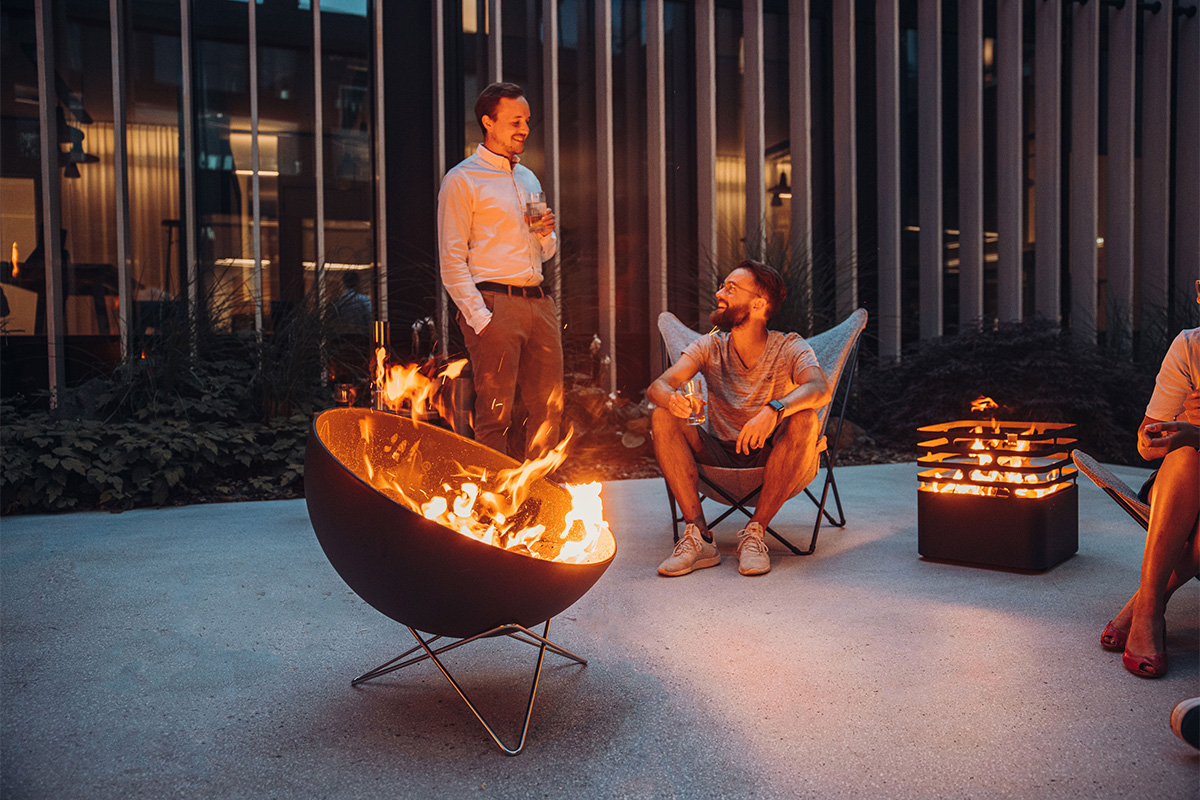 Bowl 70 star stand The 00259 Bowl 70 Star Stand integrates seamlessly into the setting, where a group of people sitting around a fire pit.